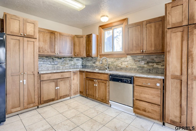 kitchen featuring light tile patterned floors, light countertops, decorative backsplash, stainless steel dishwasher, and a sink