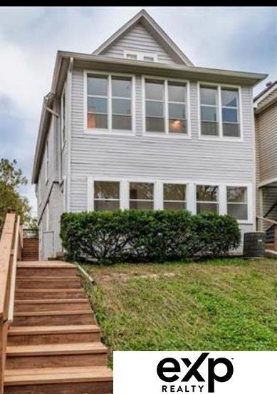 view of front of property featuring stairs and a front lawn