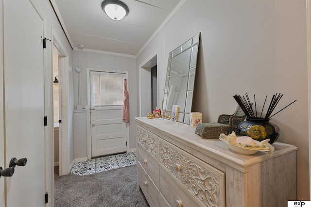hallway with carpet flooring, ornamental molding, and baseboards