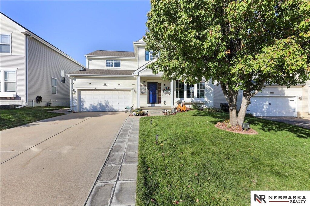 4960 S 194th St, Omaha, NE 68135 - view of front facade featuring a front lawn, an attached garage, and concrete driveway