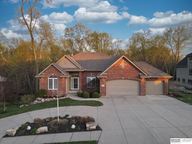 ranch-style home with a front lawn, driveway, brick siding, and a garage
