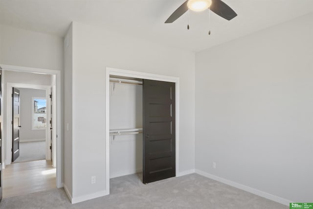 unfurnished bedroom featuring ceiling fan, a closet, baseboards, and light carpet