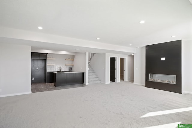 unfurnished living room with light colored carpet, baseboards, bar, and recessed lighting