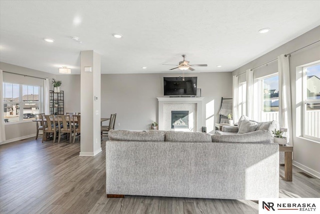 living room with baseboards, a ceiling fan, wood finished floors, and recessed lighting