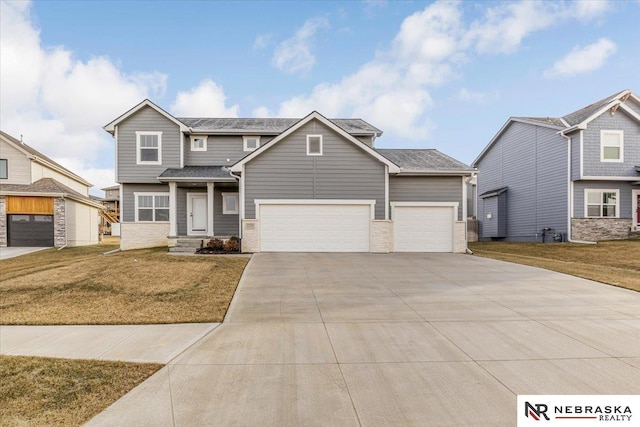 view of front facade with a garage, brick siding, a front yard, and concrete driveway