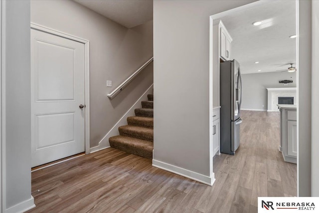 stairway featuring recessed lighting, wood finished floors, a ceiling fan, and baseboards