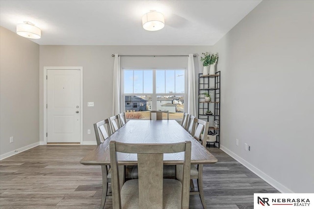 dining area with baseboards and wood finished floors