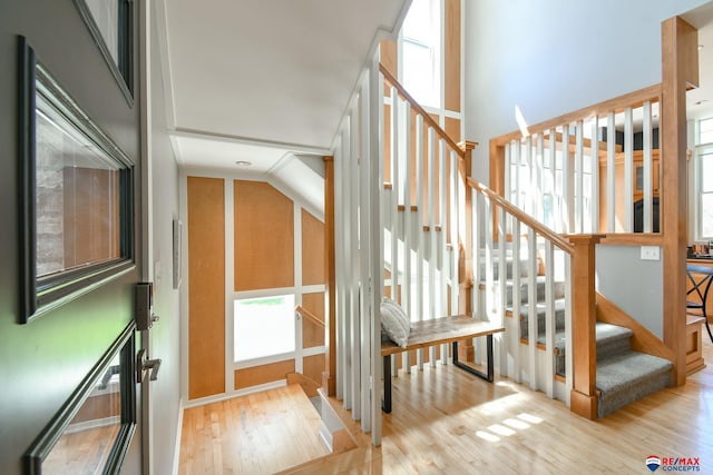 stairs featuring lofted ceiling and wood finished floors