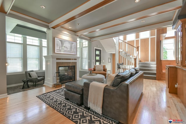 living room with baseboards, stairway, a multi sided fireplace, and light wood-type flooring