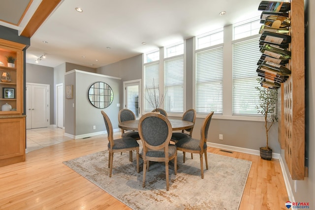dining area with baseboards, light wood-style flooring, visible vents, and plenty of natural light