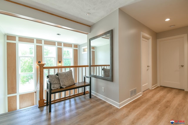 hall featuring recessed lighting, light wood-type flooring, visible vents, and baseboards