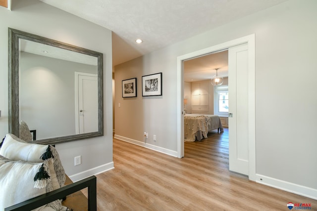 hall with recessed lighting, light wood-style flooring, and baseboards