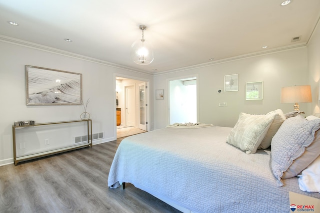 bedroom featuring wood finished floors, visible vents, and ornamental molding
