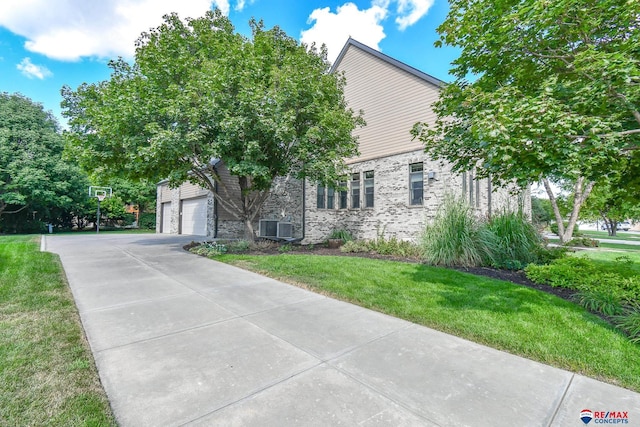 view of front facade featuring concrete driveway, a front lawn, and brick siding