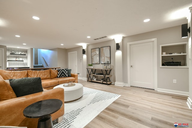 living area with recessed lighting, visible vents, light wood finished floors, and baseboards