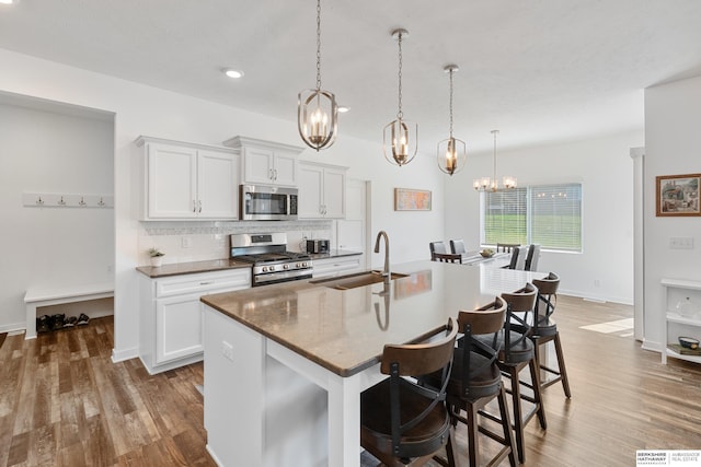 6315 N Hws Cleveland Blvd, Omaha, NE 68116 - kitchen featuring wood finished floors, a sink, a chandelier, a breakfast bar, and appliances with stainless steel finishes