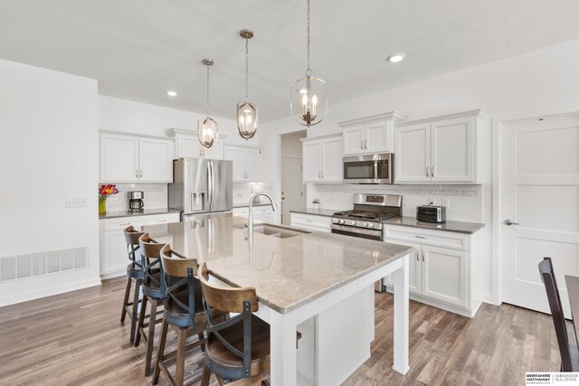 6315 N Hws Cleveland Blvd, Omaha, NE 68116 - kitchen featuring stainless steel appliances, visible vents, a sink, and backsplash