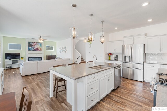 6315 N Hws Cleveland Blvd, Omaha, NE 68116 - kitchen featuring a ceiling fan, a sink, decorative backsplash, a fireplace, and appliances with stainless steel finishes