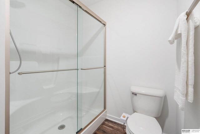 6315 N Hws Cleveland Blvd, Omaha, NE 68116 - bathroom with toilet, wood finished floors, baseboards, and a stall shower
