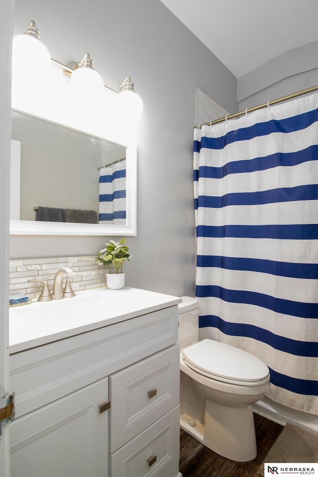 bathroom featuring toilet, a shower with shower curtain, vanity, and wood finished floors