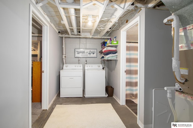 washroom featuring separate washer and dryer, baseboards, and laundry area