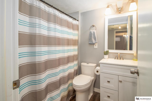 full bath with curtained shower, wood finished floors, toilet, vanity, and a textured ceiling