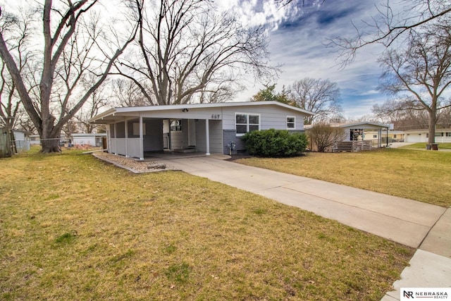 ranch-style house with concrete driveway, a front lawn, an attached carport, and fence