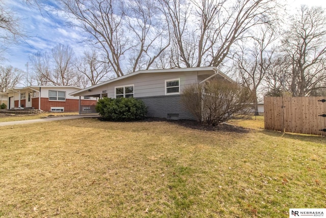view of front of house featuring brick siding, a front yard, and fence