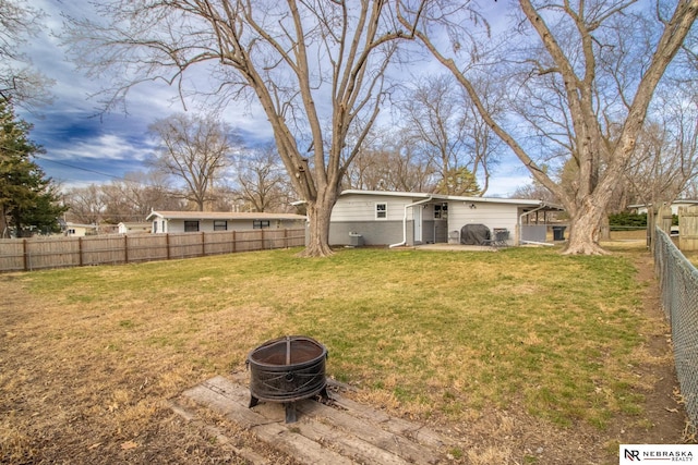 view of yard with a fire pit and a fenced backyard