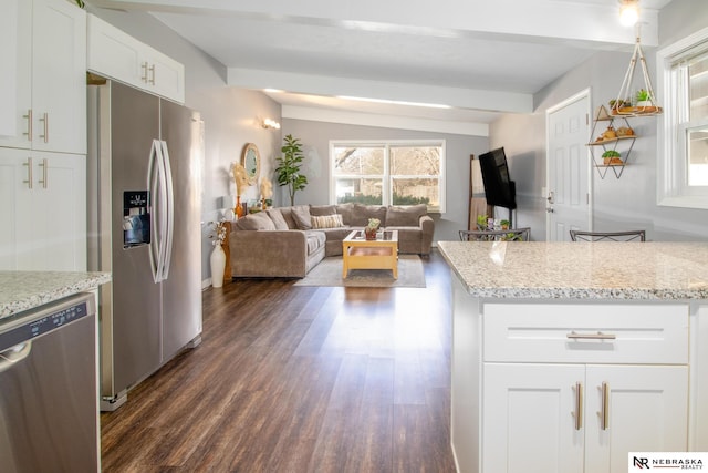 kitchen featuring stainless steel appliances, dark wood-style floors, open floor plan, and white cabinetry