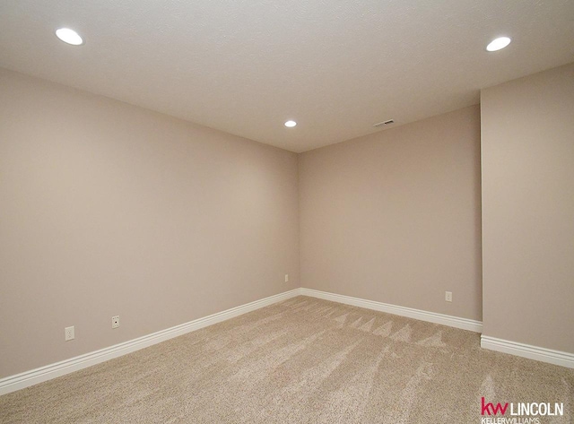 unfurnished room with recessed lighting, baseboards, and light colored carpet