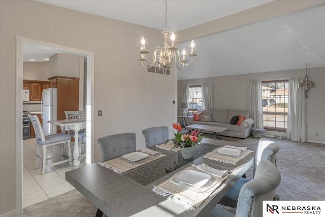dining area featuring a chandelier, light tile patterned flooring, and light carpet