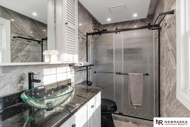 bathroom with recessed lighting, toilet, vanity, tasteful backsplash, and a stall shower
