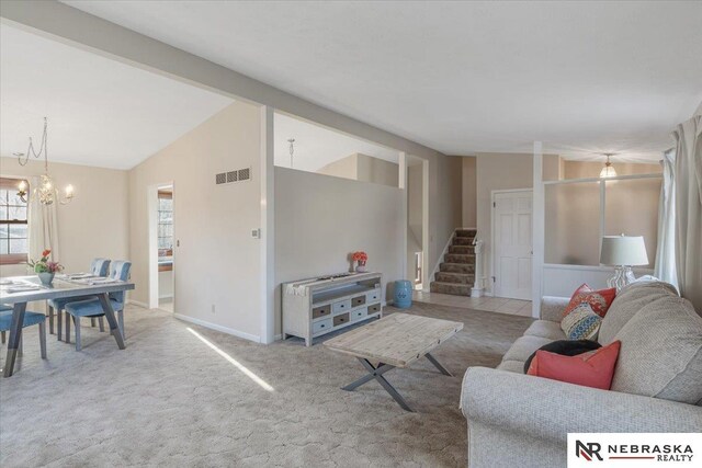 living area featuring stairway, carpet floors, lofted ceiling, a notable chandelier, and visible vents