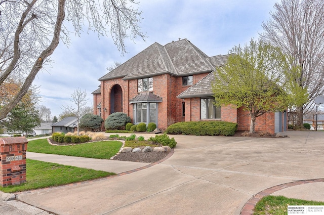 view of front facade featuring brick siding and curved driveway