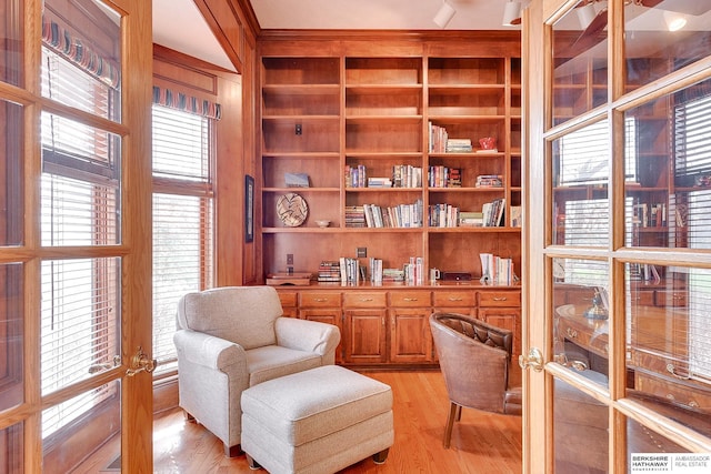 living area featuring light wood-style floors and built in shelves