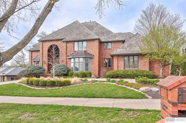traditional home with a front lawn and brick siding