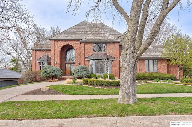 traditional-style house featuring a front lawn and brick siding