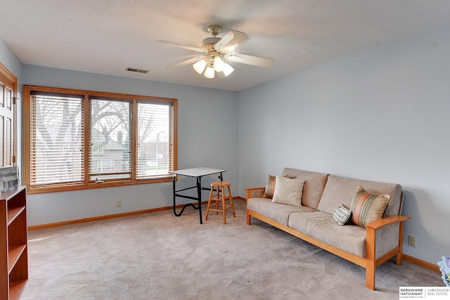 sitting room with a ceiling fan, carpet floors, and baseboards