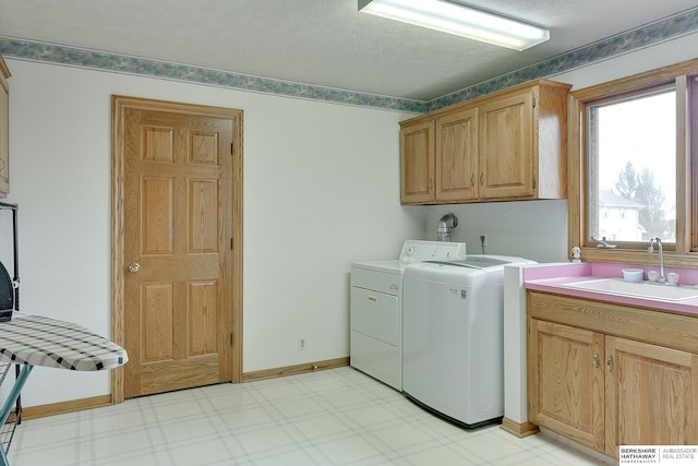 laundry room with cabinet space, separate washer and dryer, light flooring, and baseboards