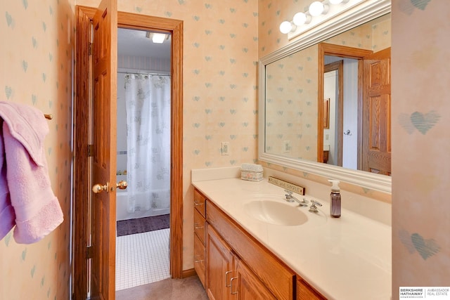 bathroom with wallpapered walls and vanity
