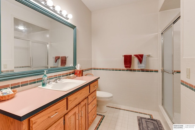 full bathroom featuring tile walls, tile patterned flooring, a shower stall, vanity, and toilet