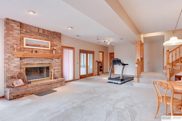 living room with carpet, stairs, and a brick fireplace