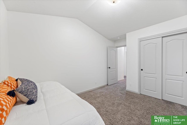 bedroom with baseboards, vaulted ceiling, carpet flooring, and a closet