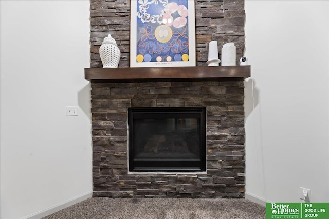 room details featuring a large fireplace, carpet flooring, and baseboards
