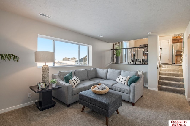 living room featuring visible vents, baseboards, carpet flooring, and stairs