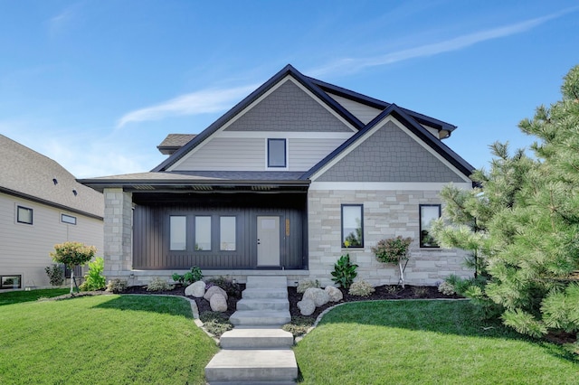 craftsman-style house with stone siding, a shingled roof, and a front yard