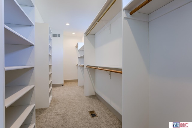 walk in closet featuring visible vents and light carpet