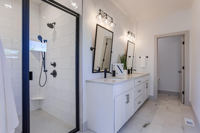 full bathroom with double vanity, a shower stall, marble finish floor, and a sink