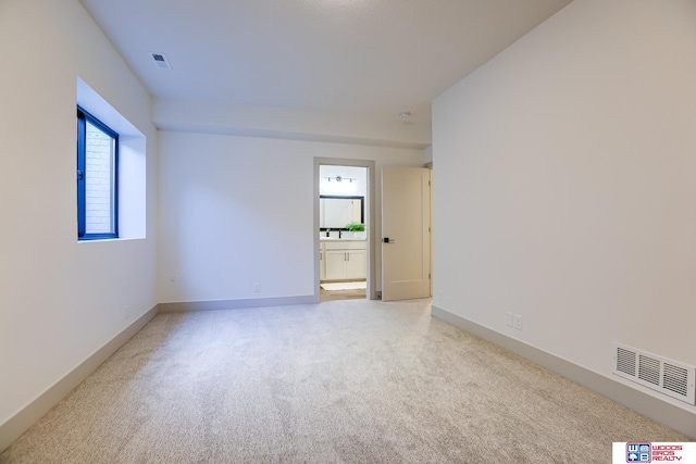 unfurnished room featuring visible vents, baseboards, and light carpet